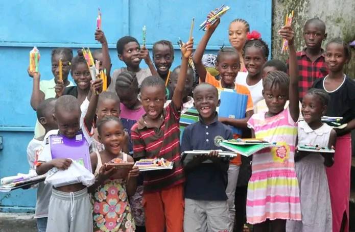 Children holding learning materials provided through PaNBA's education outreach